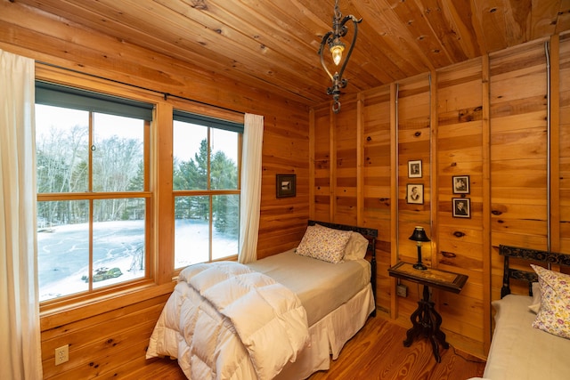 bedroom featuring wooden walls, wood ceiling, and wood-type flooring