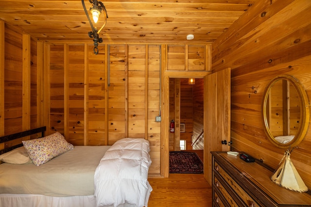 bedroom with wooden walls, wood ceiling, and wood-type flooring