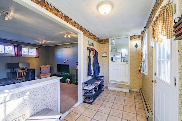 interior space with light tile patterned floors and a baseboard heating unit