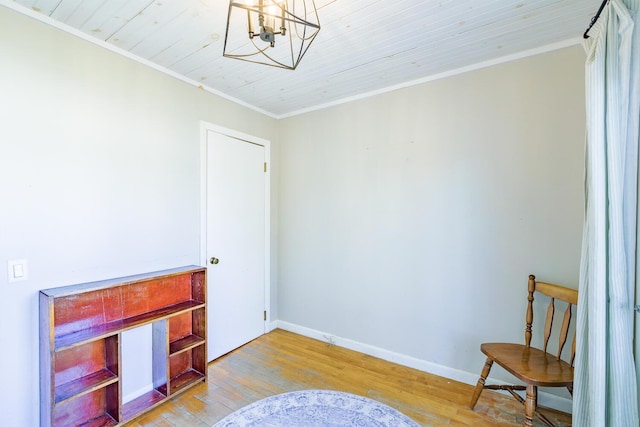 living area with a chandelier, ornamental molding, and light hardwood / wood-style flooring