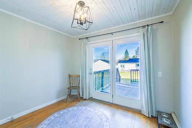 entryway with wood ceiling, ornamental molding, a chandelier, and light hardwood / wood-style floors