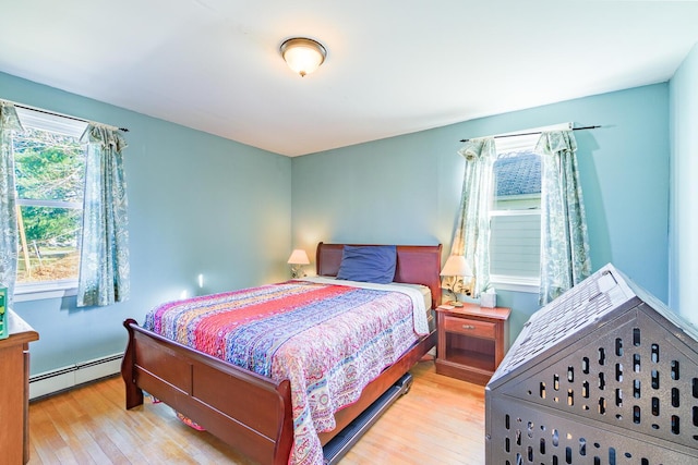 bedroom featuring light wood-type flooring and baseboard heating