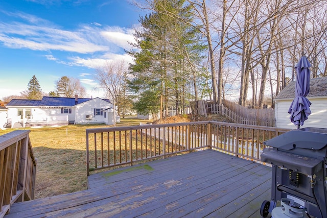 wooden deck with a yard and grilling area