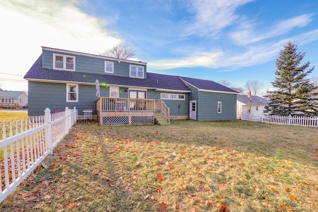 rear view of house featuring a lawn and a wooden deck