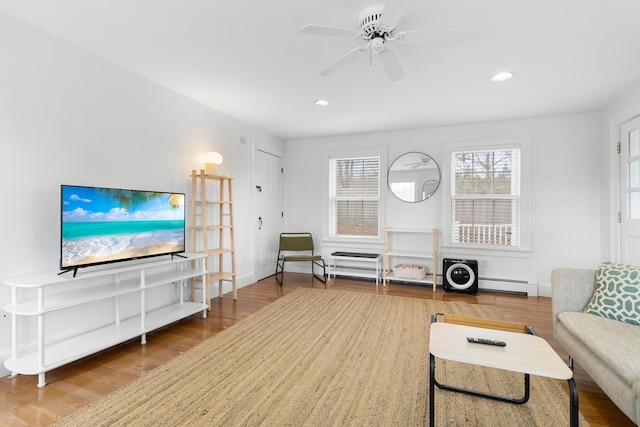 living room with ceiling fan, wood-type flooring, and baseboard heating