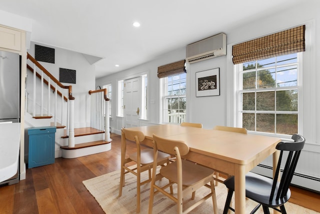 dining room featuring an AC wall unit and dark hardwood / wood-style flooring