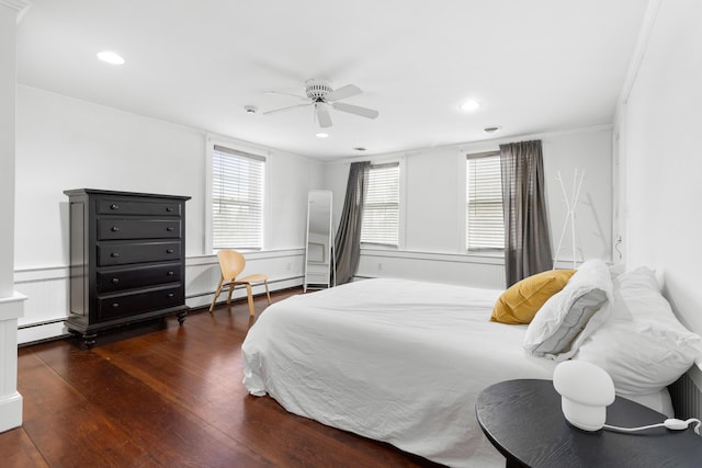 bedroom featuring baseboard heating, ceiling fan, crown molding, and dark wood-type flooring