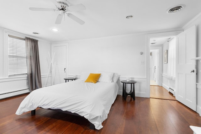 bedroom featuring ceiling fan, dark hardwood / wood-style flooring, a baseboard radiator, and ornamental molding