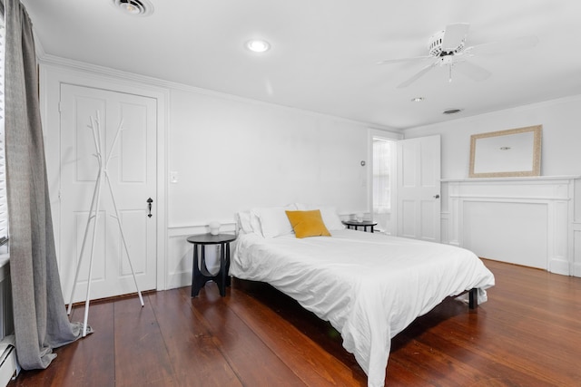 bedroom featuring ceiling fan, dark hardwood / wood-style flooring, crown molding, and a baseboard radiator