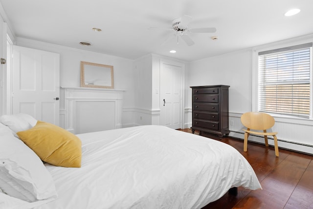 bedroom with baseboard heating, ceiling fan, and dark wood-type flooring