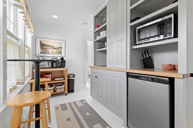 kitchen featuring butcher block counters and stainless steel dishwasher