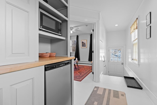 kitchen featuring white cabinetry, built in microwave, wooden counters, stainless steel dishwasher, and ornamental molding