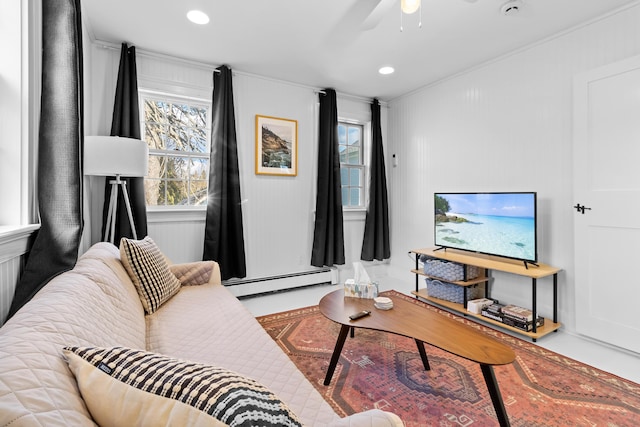 living room with baseboard heating, ornamental molding, and ceiling fan