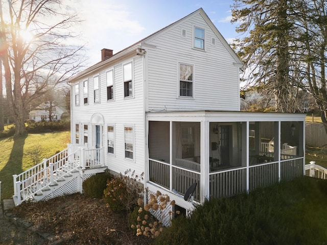 rear view of house featuring a sunroom