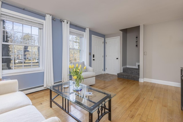 living room with a baseboard radiator and light hardwood / wood-style flooring