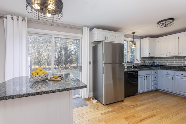 kitchen with white cabinetry, dishwasher, sink, stainless steel fridge, and light hardwood / wood-style floors