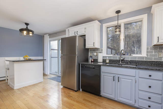 kitchen featuring dishwasher, sink, stainless steel fridge, decorative backsplash, and white cabinets