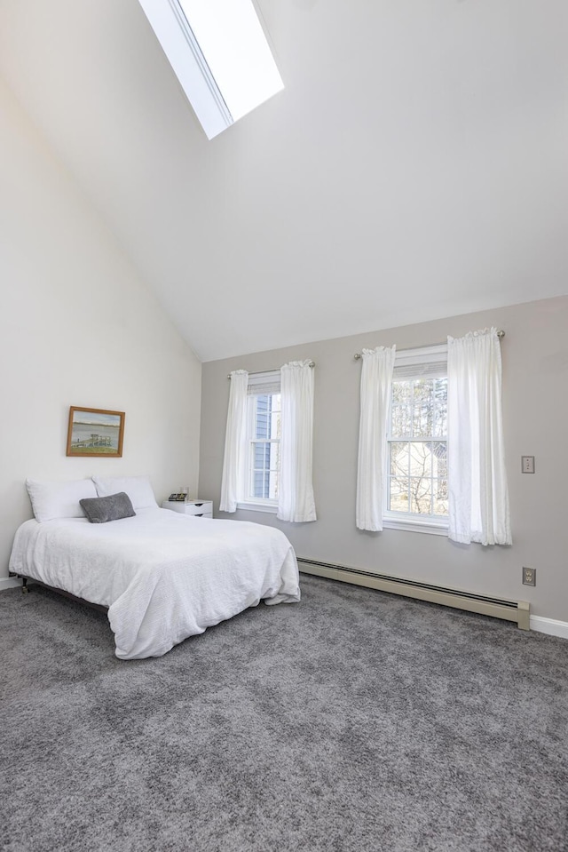 carpeted bedroom featuring multiple windows, baseboard heating, and vaulted ceiling with skylight