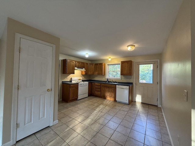 kitchen featuring sink, light tile patterned flooring, and white appliances