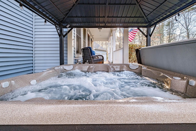 snow covered patio with a gazebo and a hot tub