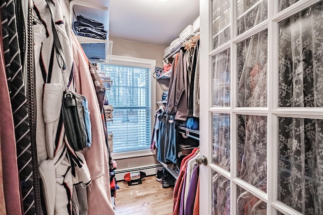 spacious closet featuring a baseboard radiator and hardwood / wood-style flooring