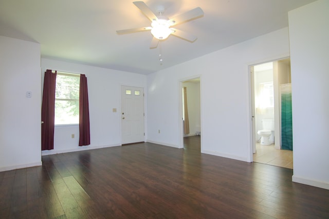 empty room with ceiling fan and dark wood-type flooring