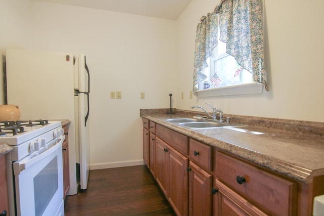 kitchen featuring white gas range, sink, and dark wood-type flooring