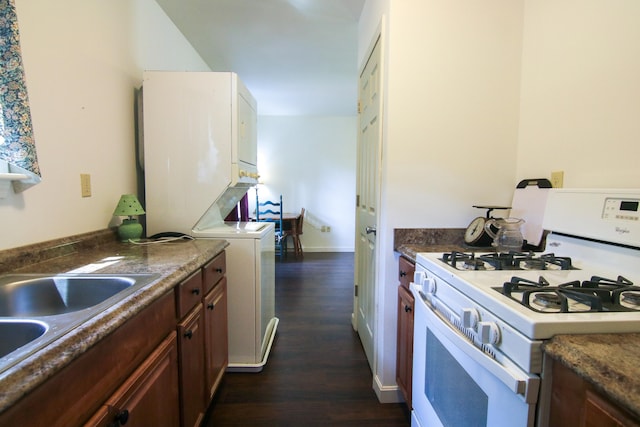 kitchen featuring dark hardwood / wood-style flooring, white gas range oven, and sink