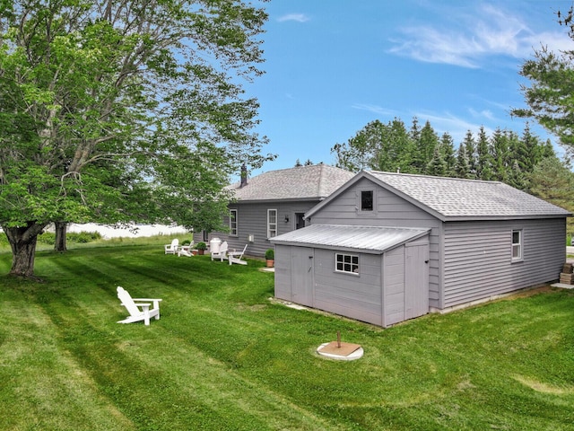 back of house featuring a lawn and a storage shed