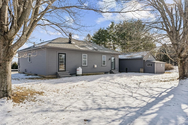 snow covered property featuring a storage unit