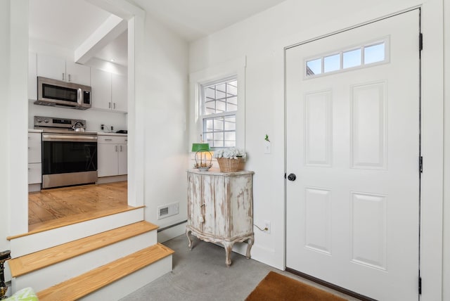 entrance foyer featuring concrete flooring and a healthy amount of sunlight