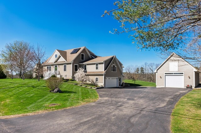 view of home's exterior with a lawn, an attached garage, solar panels, and aphalt driveway