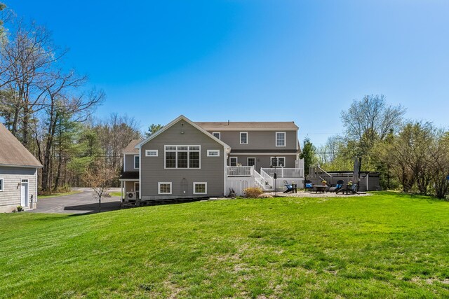 back of property featuring stairs, a patio area, and a lawn
