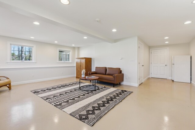 living area with recessed lighting, concrete floors, and baseboards