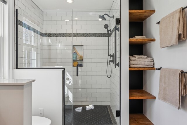 bathroom with recessed lighting, toilet, and a shower stall