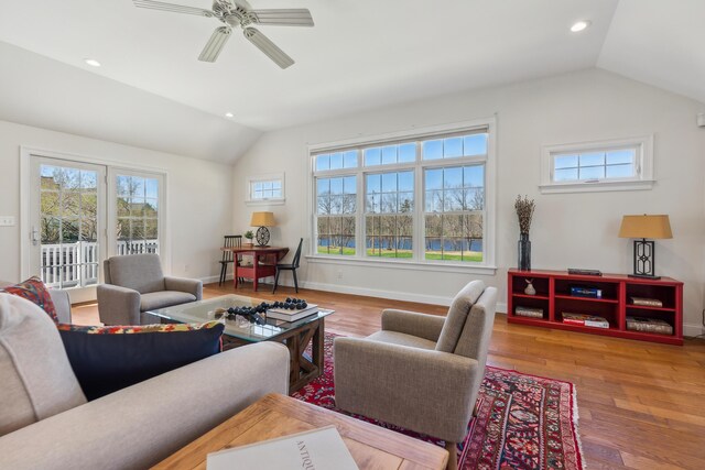 living room with baseboards, a ceiling fan, wood finished floors, and lofted ceiling