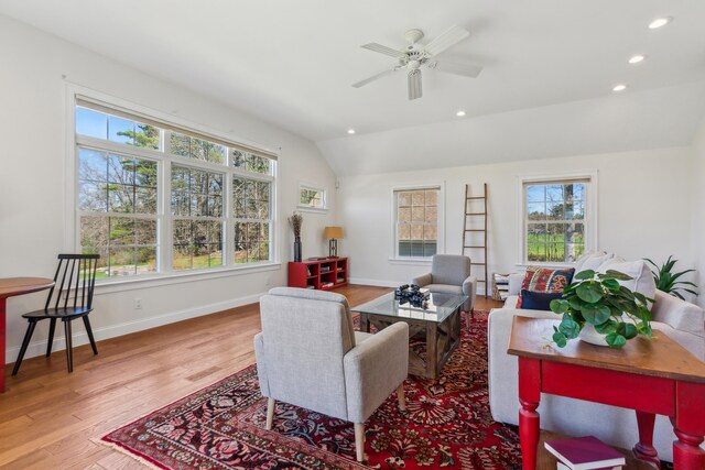 living area featuring vaulted ceiling, a wealth of natural light, and wood finished floors