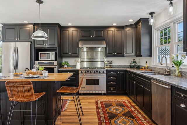 kitchen featuring recessed lighting, a sink, appliances with stainless steel finishes, and under cabinet range hood