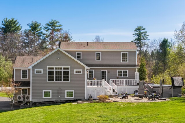 rear view of property with a deck, stairs, a patio area, an outdoor fire pit, and a yard