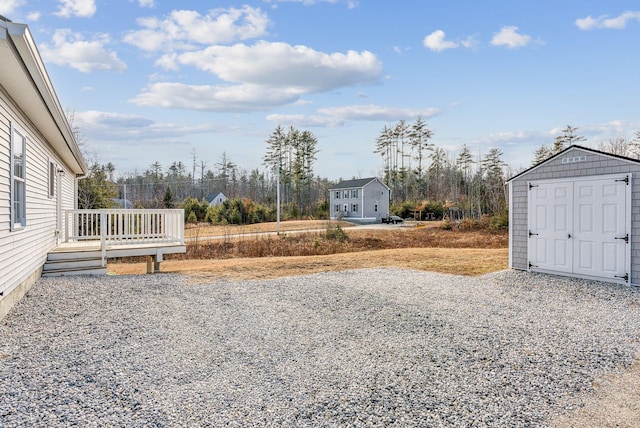 view of yard featuring a deck and a storage shed