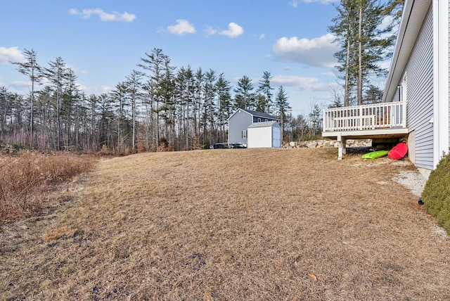 view of yard featuring a deck and a storage unit