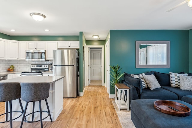 kitchen featuring appliances with stainless steel finishes, white cabinets, and tasteful backsplash