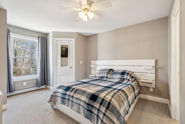 carpeted bedroom with ceiling fan and a baseboard heating unit