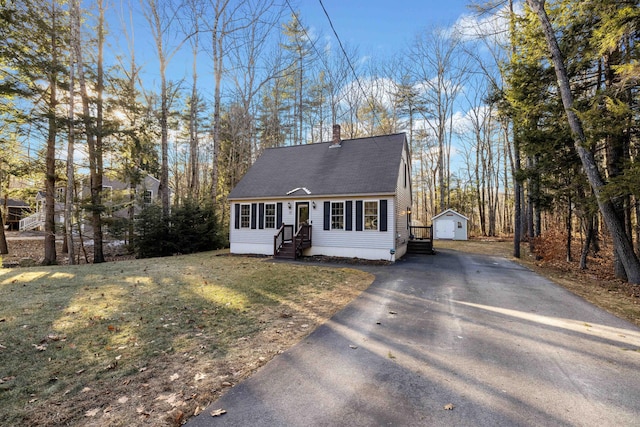 view of front of house with an outbuilding, a front lawn, and a garage