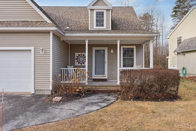 view of front of property featuring a porch, a garage, and a front yard