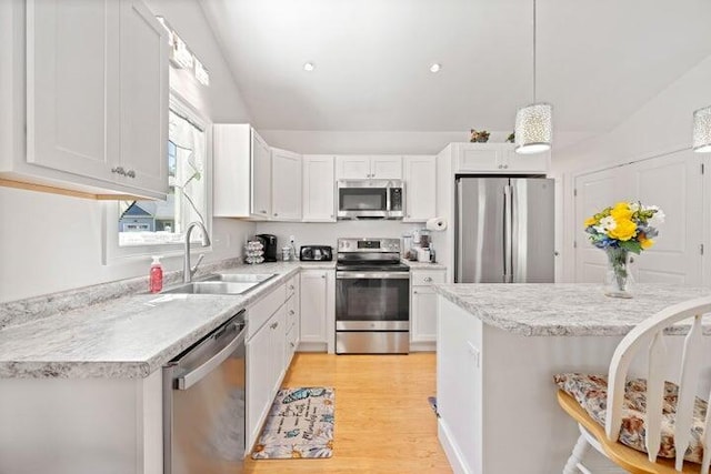 kitchen with pendant lighting, white cabinets, sink, and appliances with stainless steel finishes