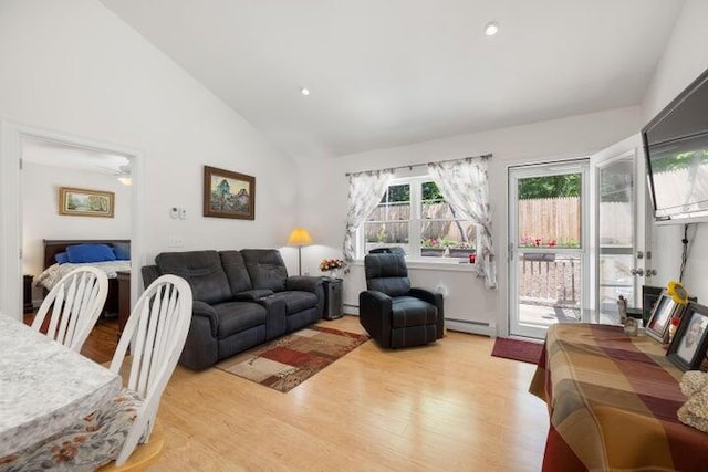 living room with light hardwood / wood-style flooring, vaulted ceiling, and baseboard heating