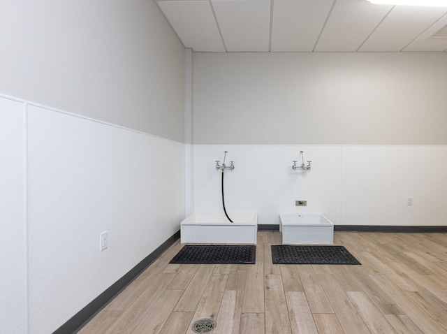 clothes washing area with light wood-type flooring and hookup for a washing machine