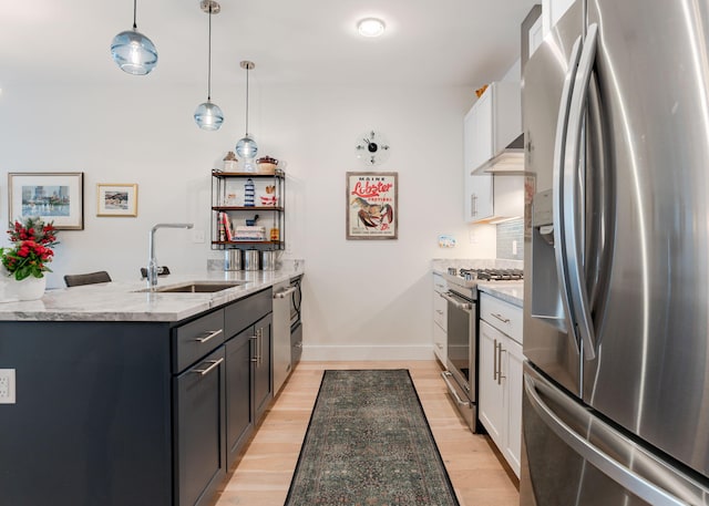 kitchen featuring white cabinets, appliances with stainless steel finishes, light stone countertops, and hanging light fixtures