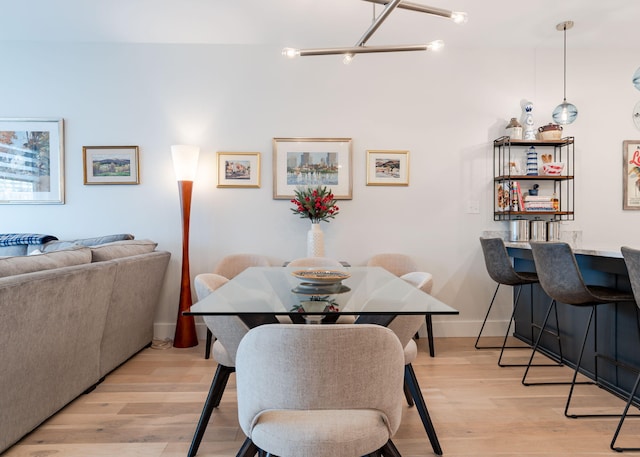 dining space featuring light hardwood / wood-style floors and a chandelier